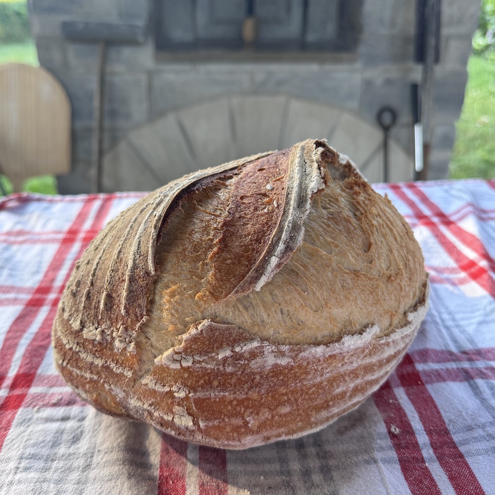 Soft, open crumb. Chewy crust. Gentle sourdough tang. Made the traditional way with just flour, water, sea salt and wild yeast starter, this naturally leavened loaf is slow fermented and baked on the hearth of a wood-fired oven. The result is a simple, honest bread with rustic character and everyday versatility — just as good with butter as it is alongside any meal.